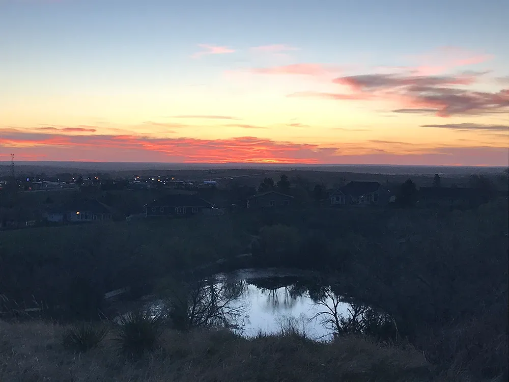 Landscape showing a sunset and a small pond